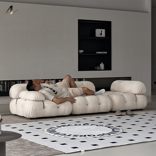 Real-person comfort test of the Hiksnra Camaleonda sofa, showing a person lying on its resilient foam cushions with supportive cushioning.