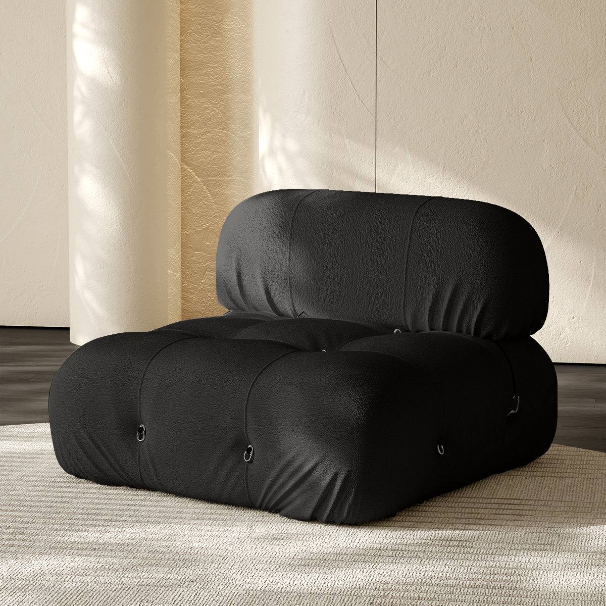 Armless single module sofa in black, tufted back and padded roll cushions.