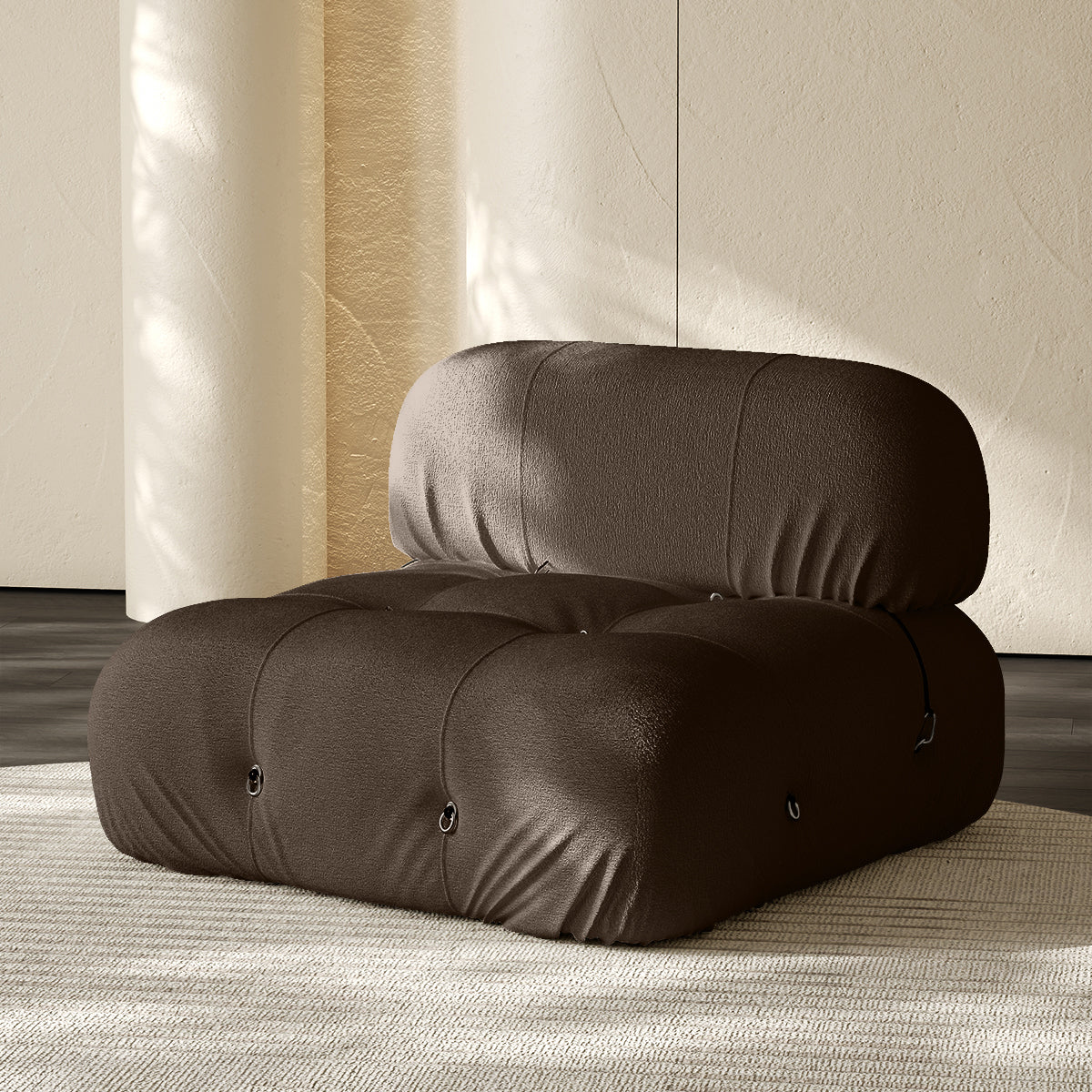 Armless single module sofa in dark gray, tufted back and padded roll cushions.