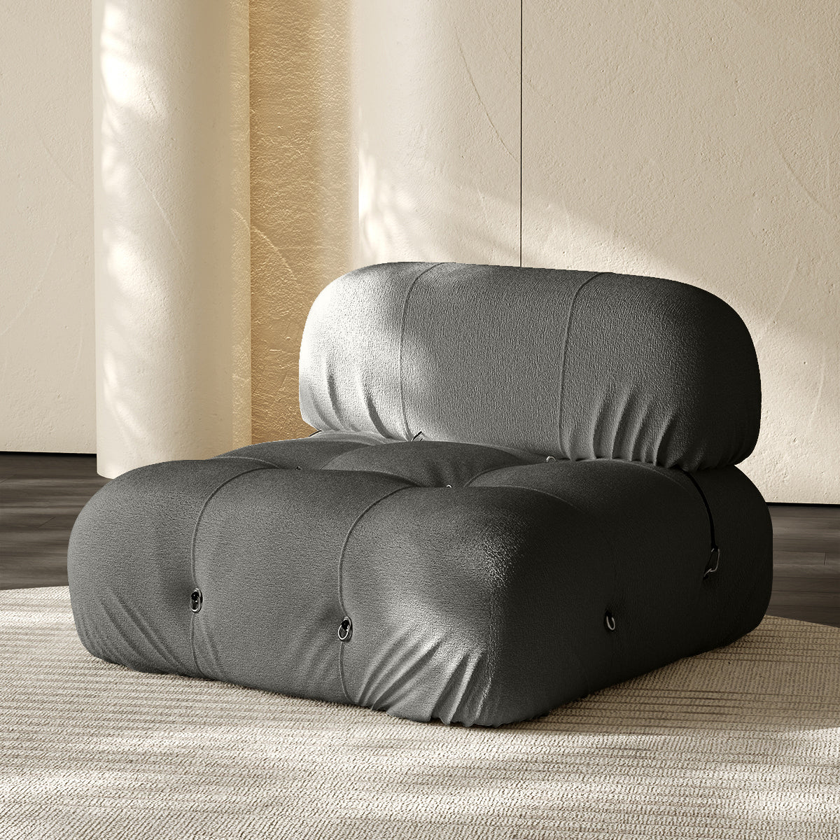 Armless single module sofa in gray, tufted back and padded roll cushions.