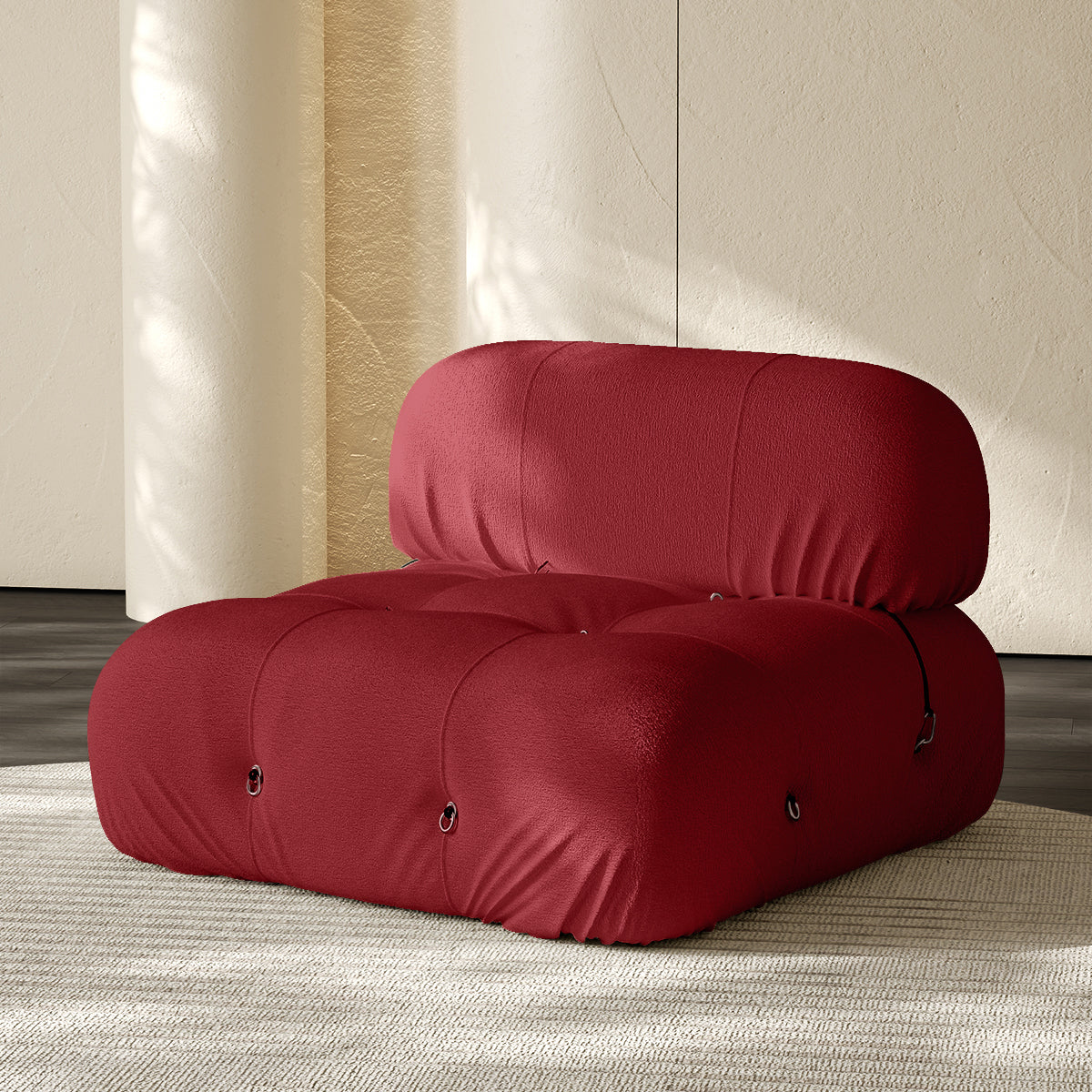 Armless single module sofa in red, tufted back and padded roll cushions.