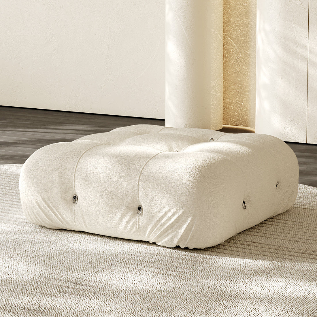 Cream square ottoman with tufted button details and plush compression cushioning.