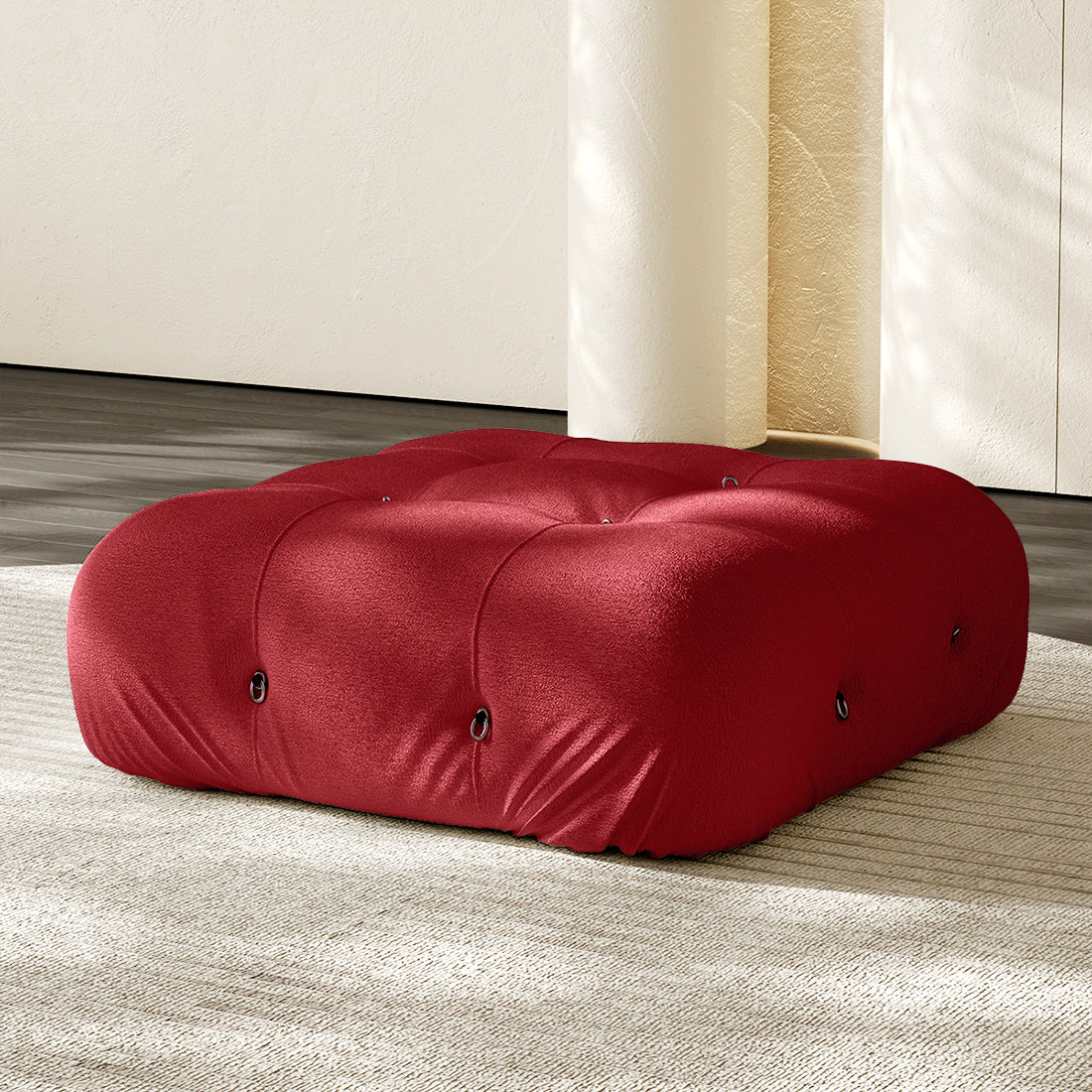 Red square ottoman with tufted button details and plush compression cushioning.