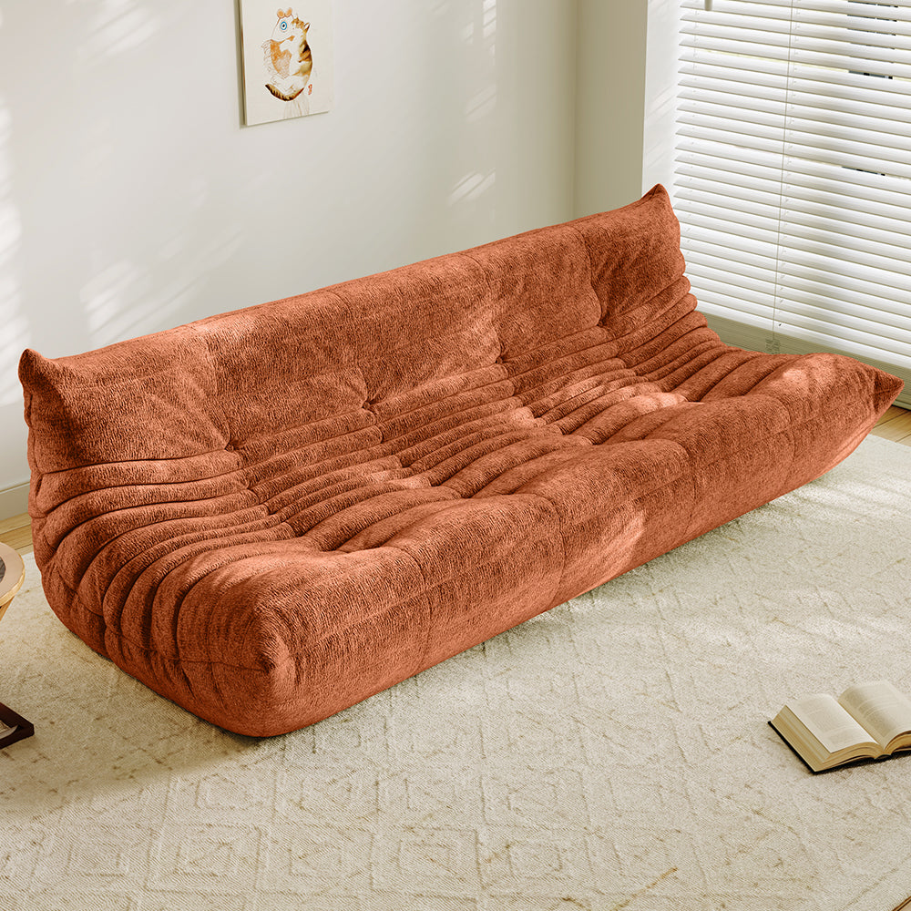 4-seater vacuum-packed sofa in rust orange, tufted cushions and ribbed backrest.