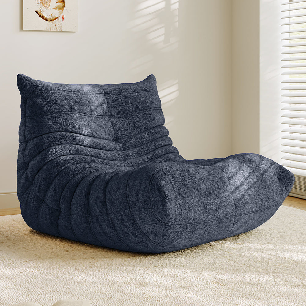 Navy blue lounge sofa chair with cushioned backrest, armrest, and curved seat section.