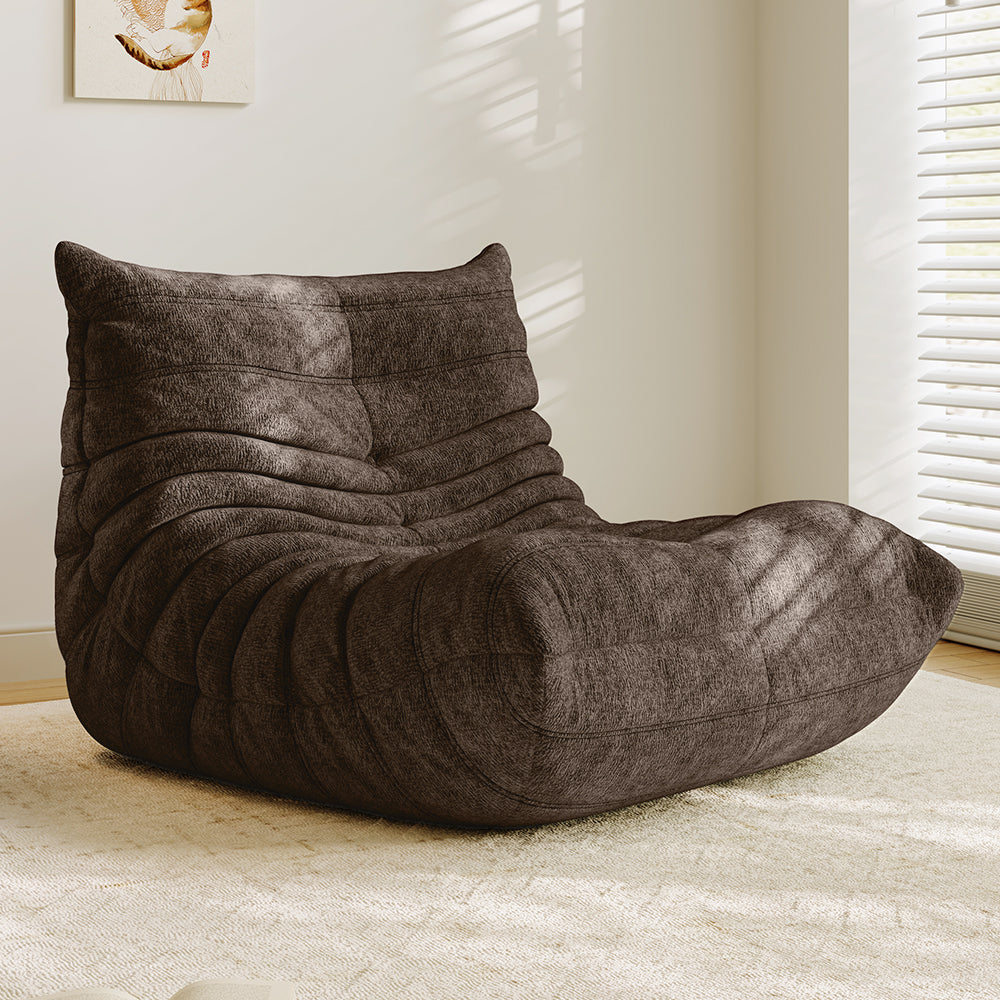 Brown lounge sofa chair with thick padded backrest, curved seat, and quilted stitching.