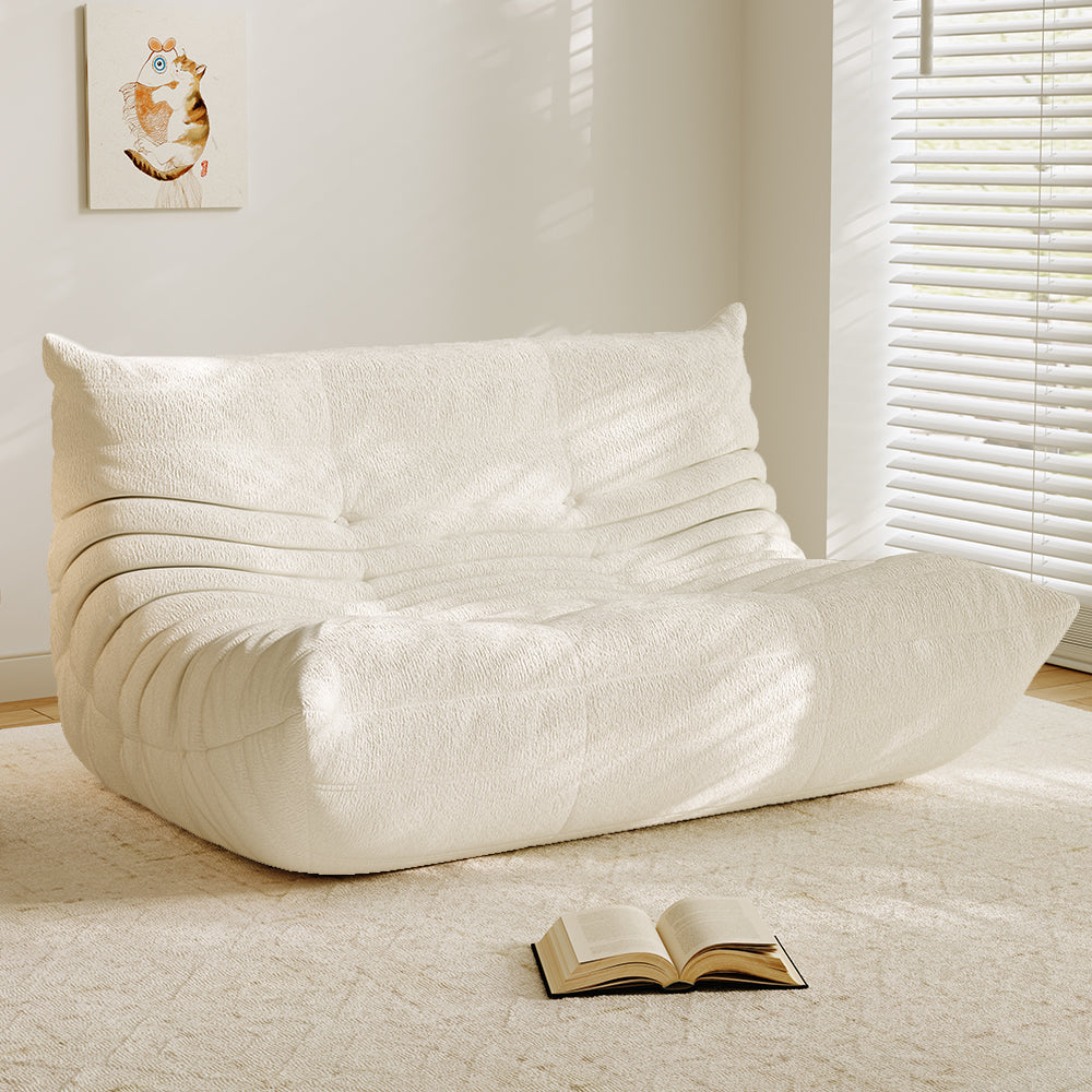 White velvet-look loveseat sofa with tufted back and curved chaise seat
