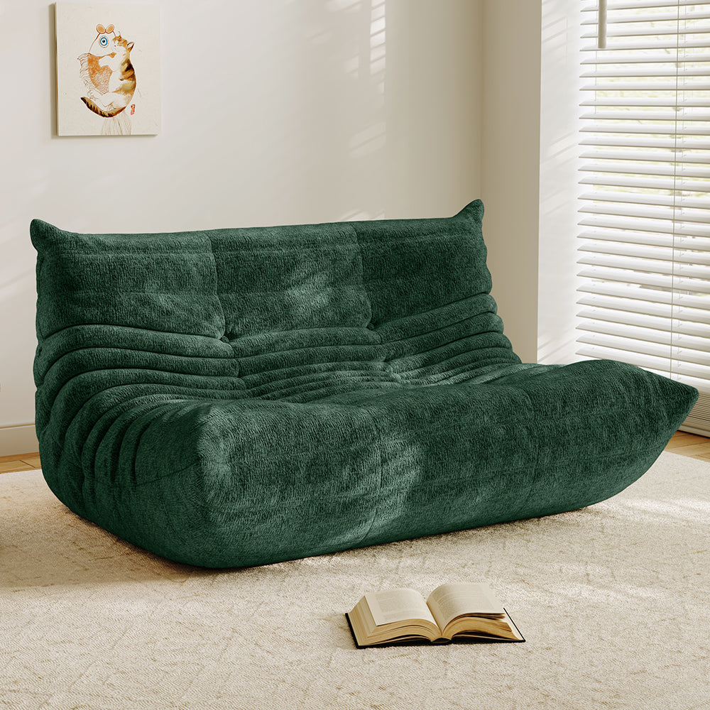 Deep green velvet-look loveseat sofa with tufted back and curved chaise seat