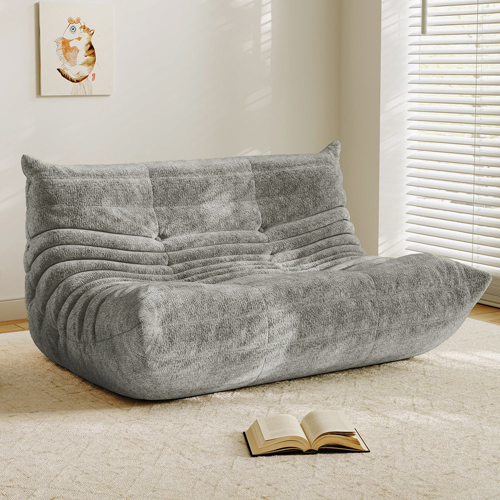 Light gray velvet-look loveseat sofa with tufted back and curved chaise seat