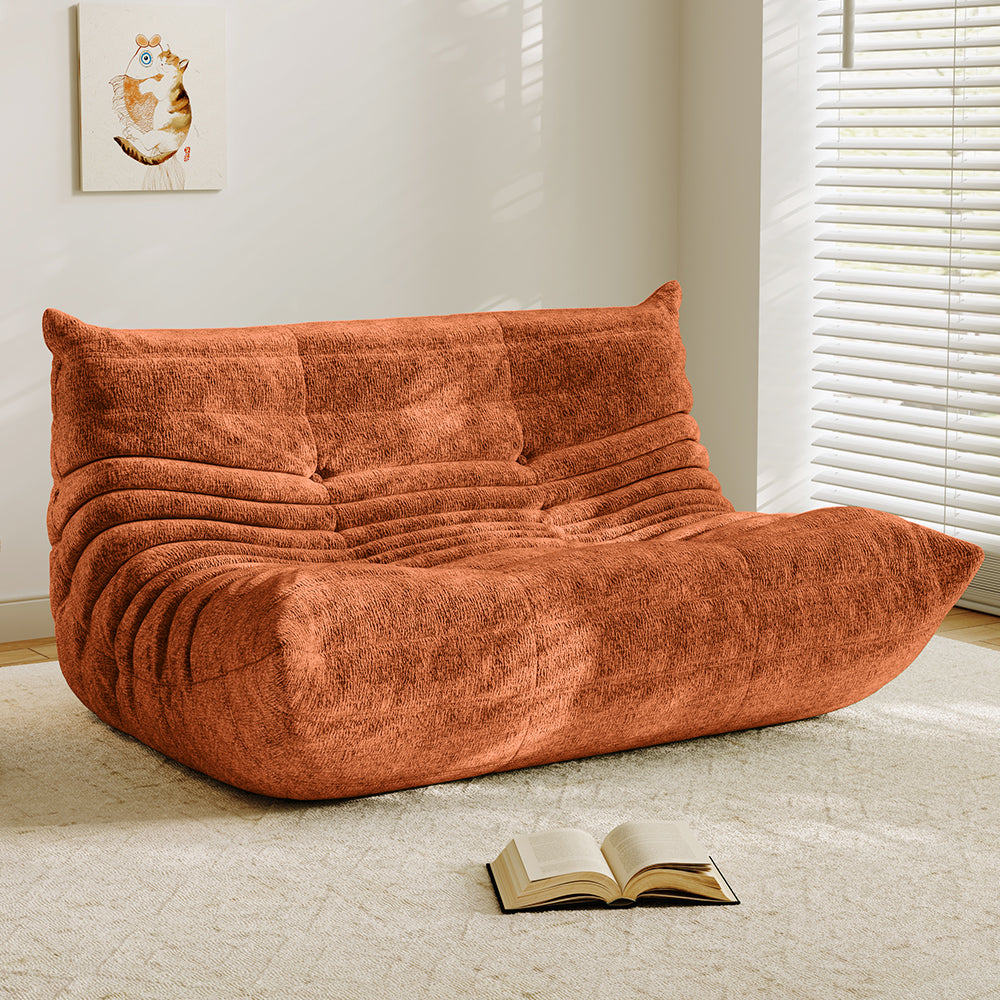 Orange velvet-look loveseat sofa with tufted back and curved chaise seat